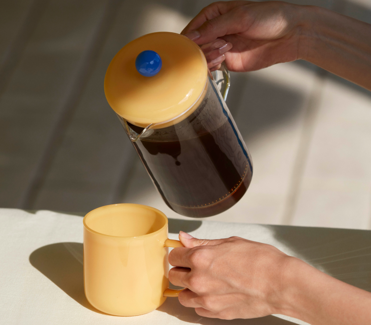 French Press Brewer Clear sirviendo café French Press Brewer Clear de cristal sirviendo café en una taza