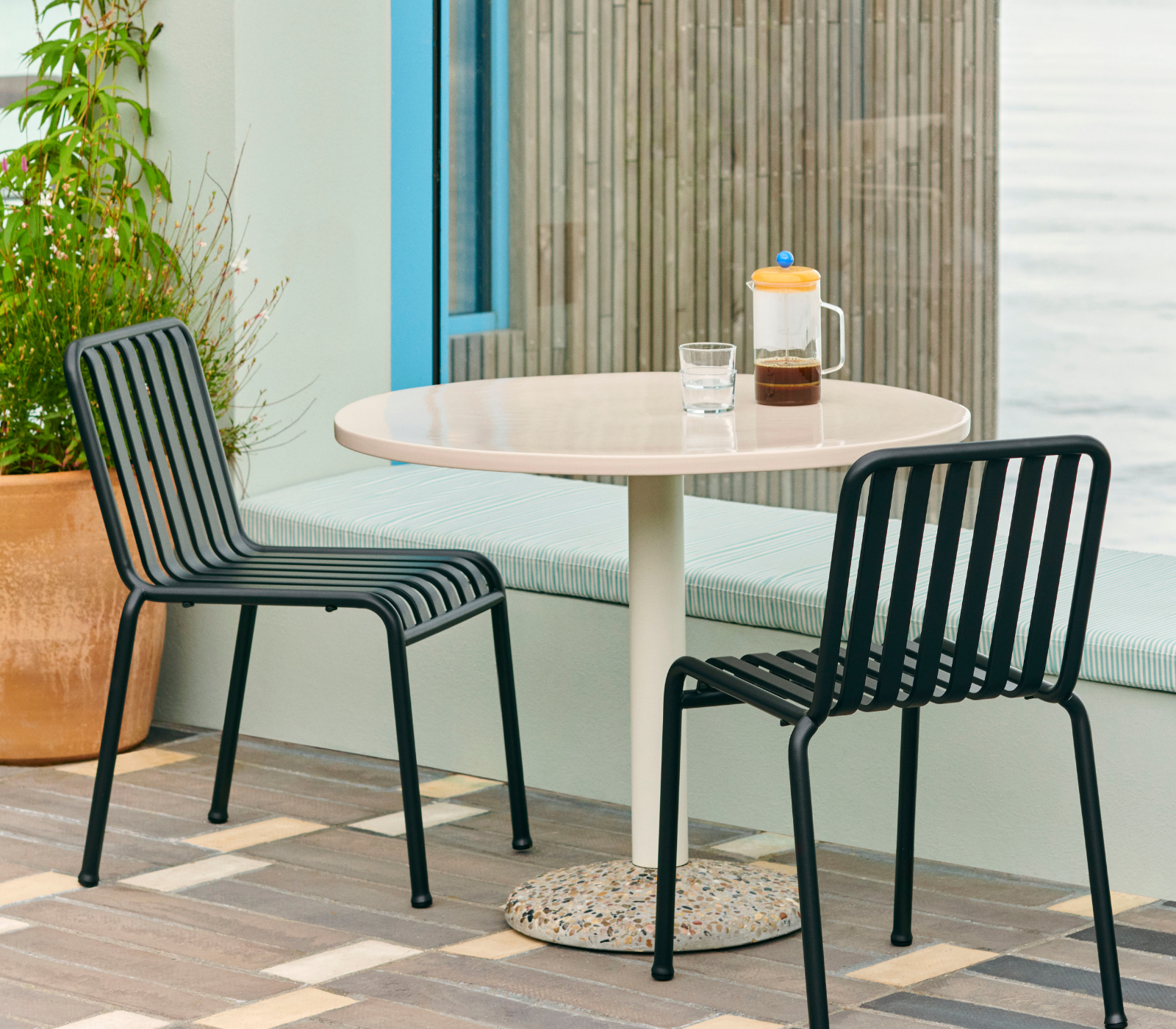 French Press Brewer Clear en terraza con mesa y sillas French Press Brewer Clear de cristal con café sobre una mesa en una terraza