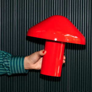 Pao Portable Lamp portátil de diseño en color rojo sostenida en la mano