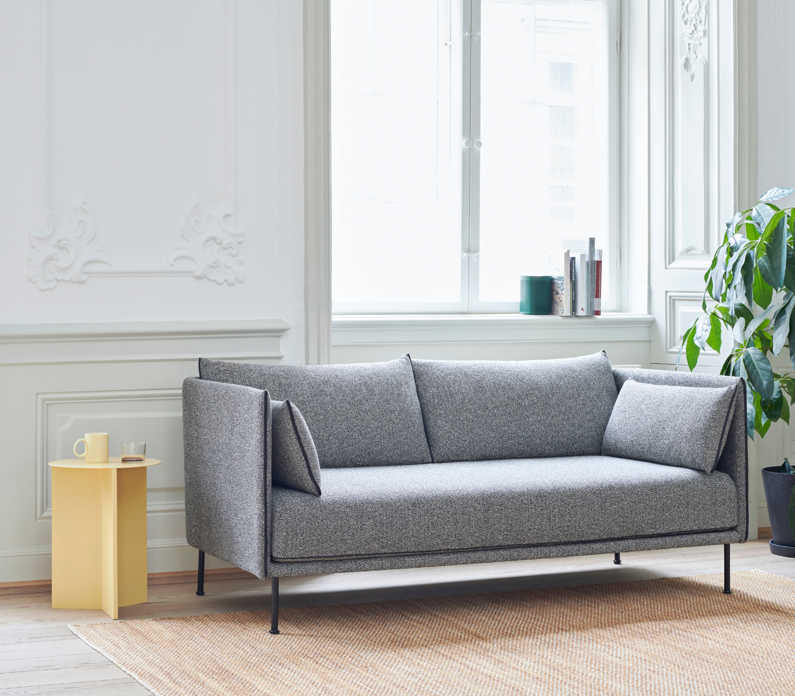 Slit Table amarilla junto a sofá en salón Slit Table de diseño en color amarillo junto a un sofá en un salón